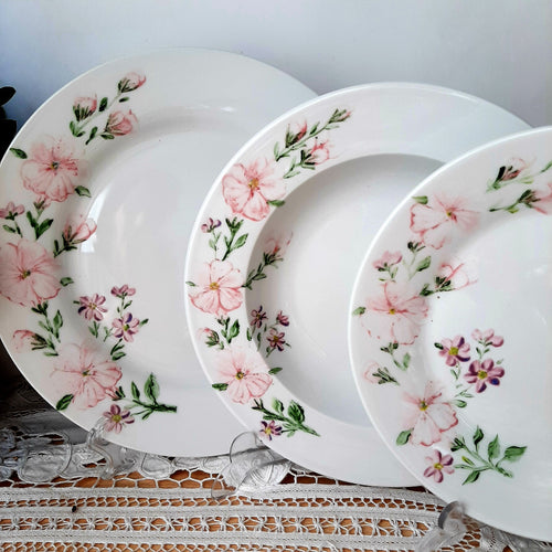 vajilla pintada a mano con petunias y violetas en un ramillete en el lado izquierdo del plato en color rosa y morado no encontraras otra igual diseño único , en una vajilla clásica 