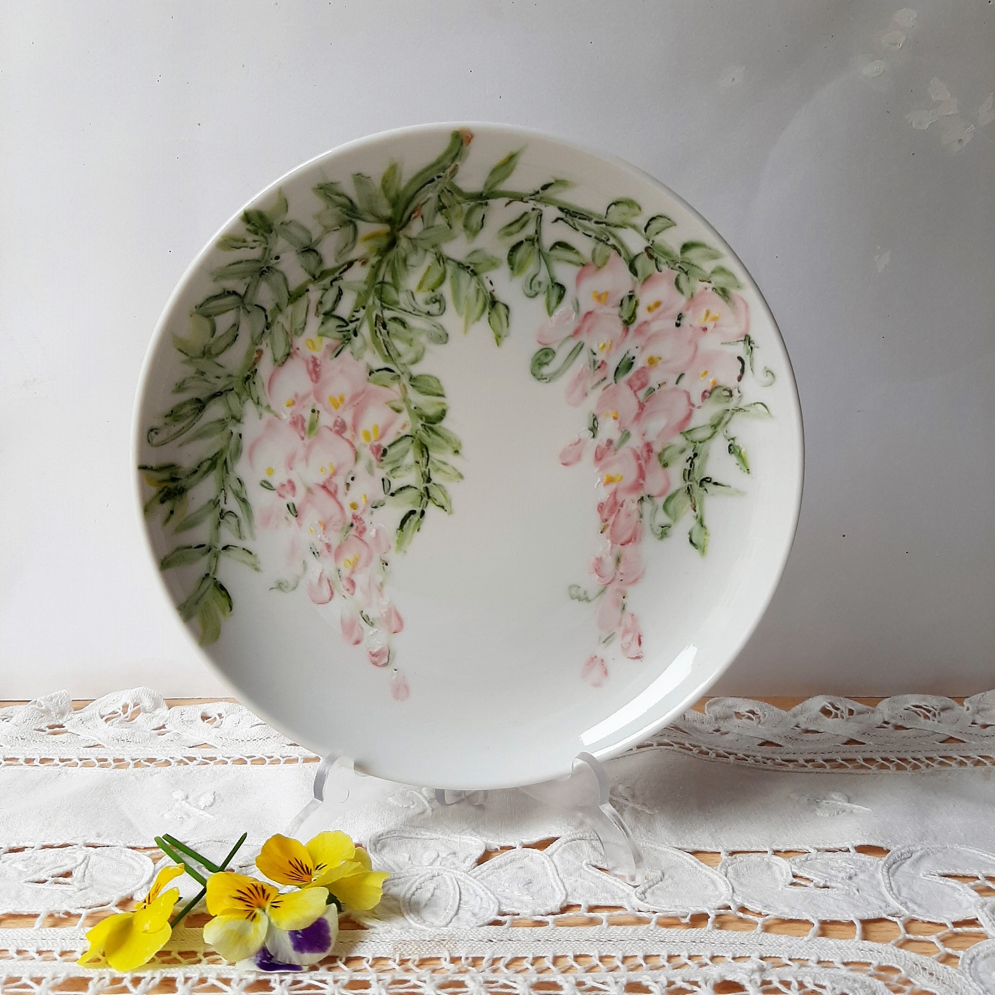 intadas con Wisteria o glicinias, esas flores que en las pérgolas cuelgan tan vistosas y tienen un olor tan sutil que parece apreciarse hasta en el plato y las hay en muy diversos tonos de colores. Plato porcelana moderno. Cuelgan dos ramos desde el borde con unas bonitas glicinias.