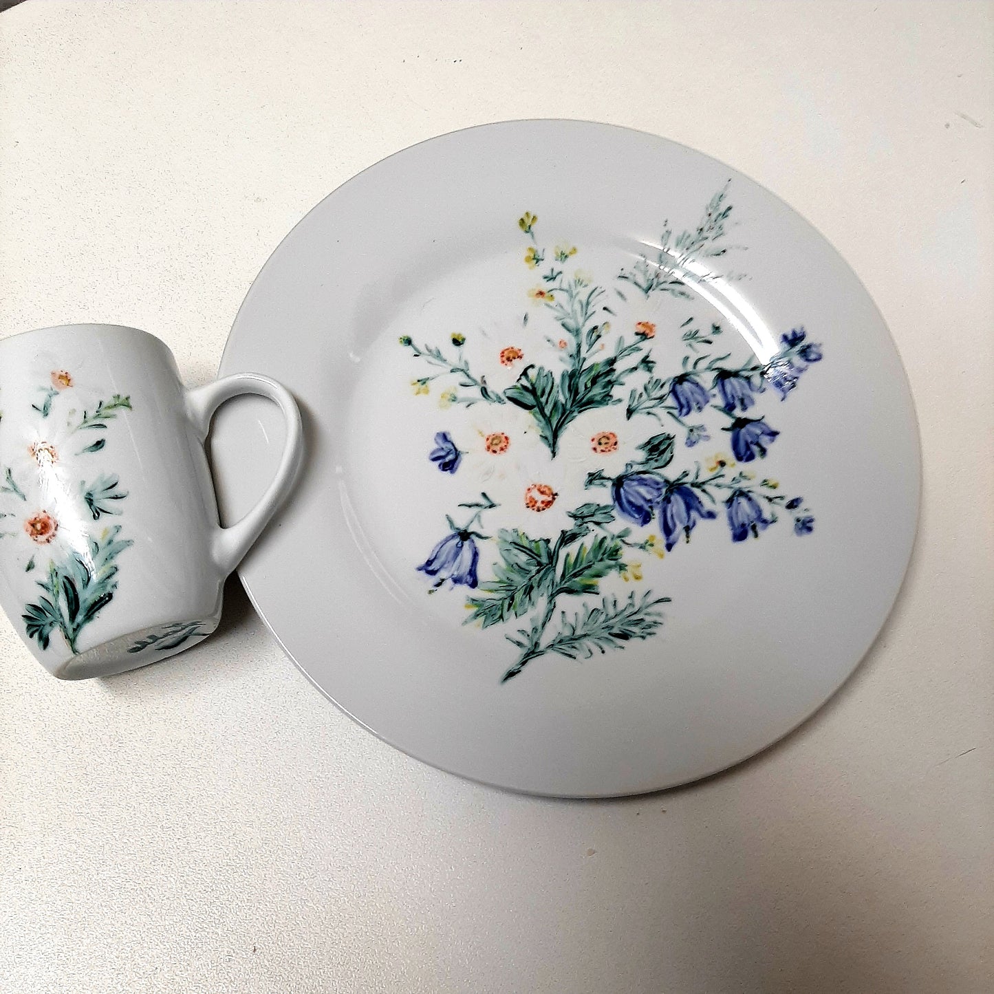 Plato y taza de porcelana esmaltado, pintado a mano, margaritas con silvestres, objeto artesanal, arte floral, únicos.