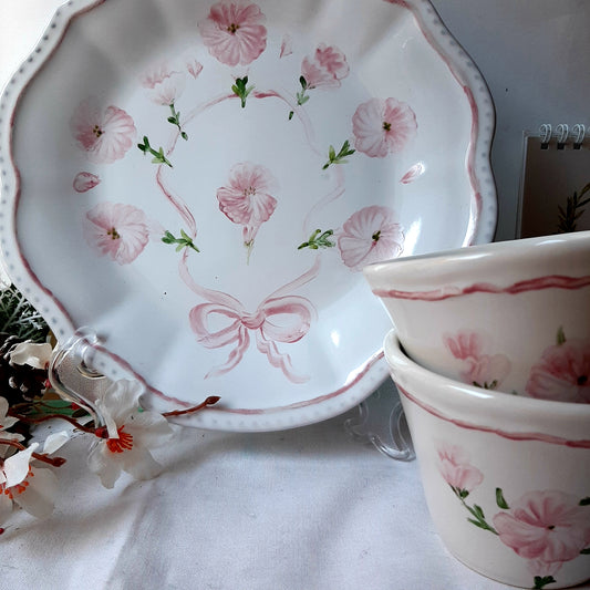 Vendo set de 2 tazas y plato a juego pintado con unas petunias en color rosa haciendo ramillete y en el plato unidas con un lazodo